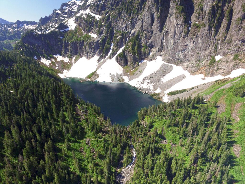 an aerial shot of lake serene surrounded by trees