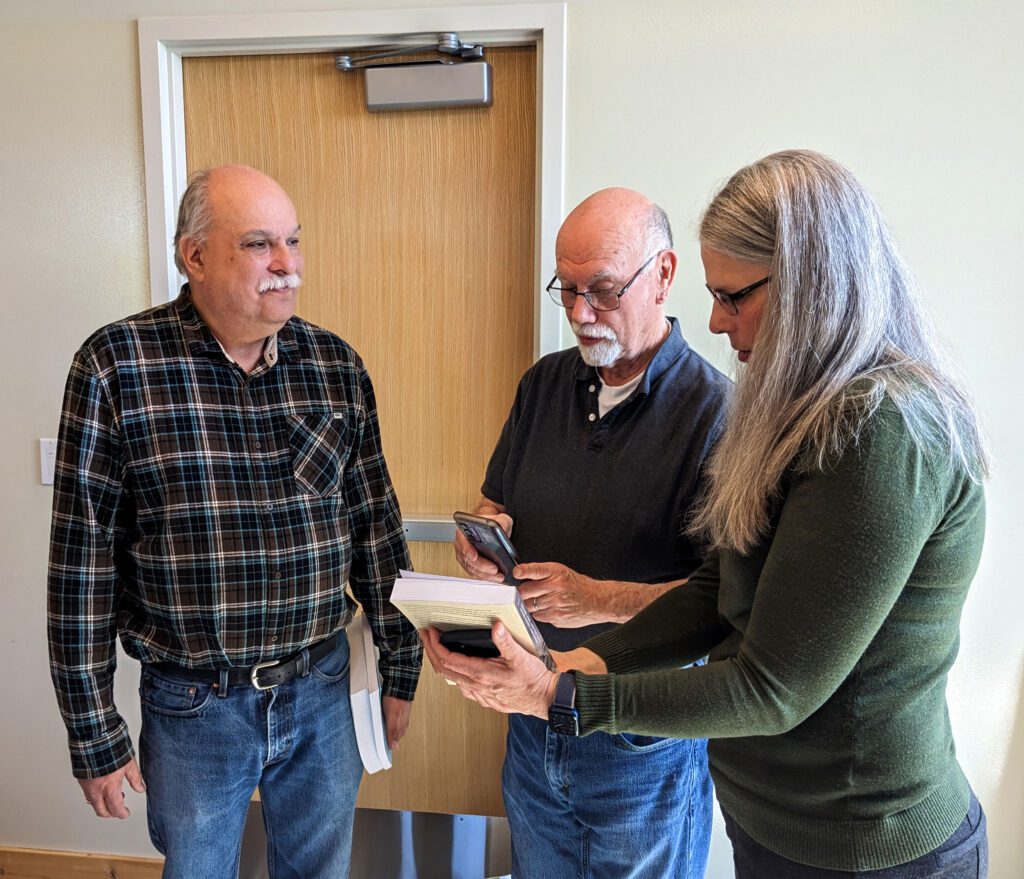 Elder Daryl Williams, Elder Greig Arnold and Forterra CEO and President Michelle Connor talk about a book they're holding