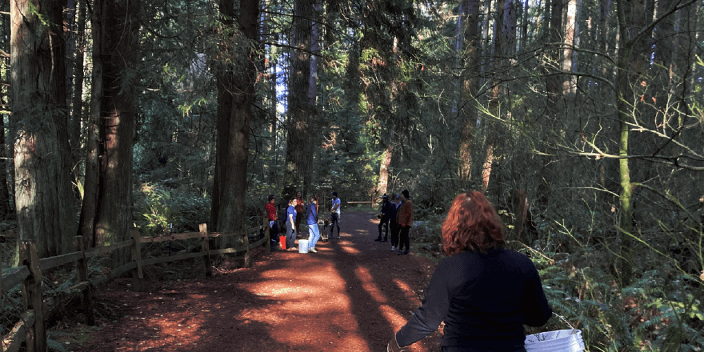 People walking through a path in the woods.