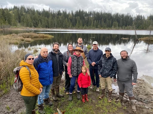A photo of a group of people by a lake.