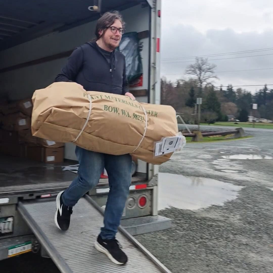 Forterra's Project Manager Daniel Hatchet unloading a soon-to-be-planted tree from the delivery truck.