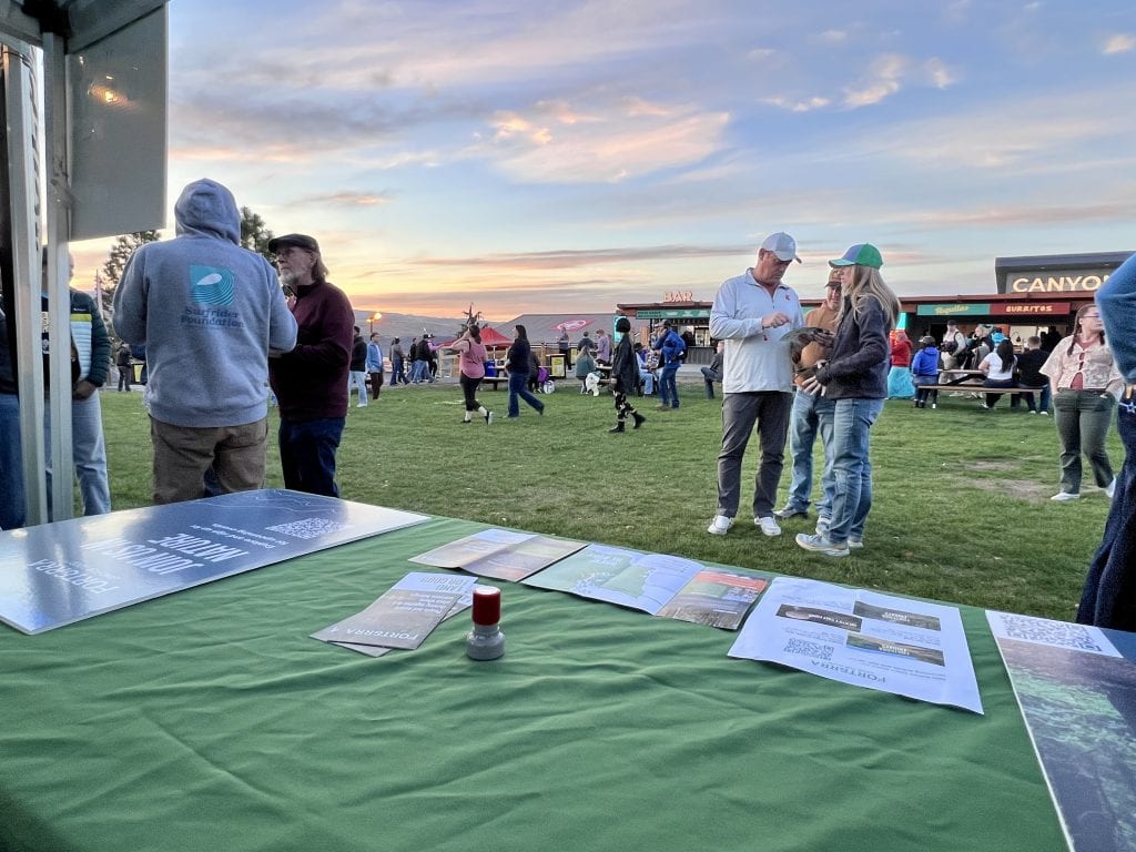 Concertgoers visit the Forterra's table at the All At Once Village Green at The Gorge Amphitheatre before the Jack Johnson concert.