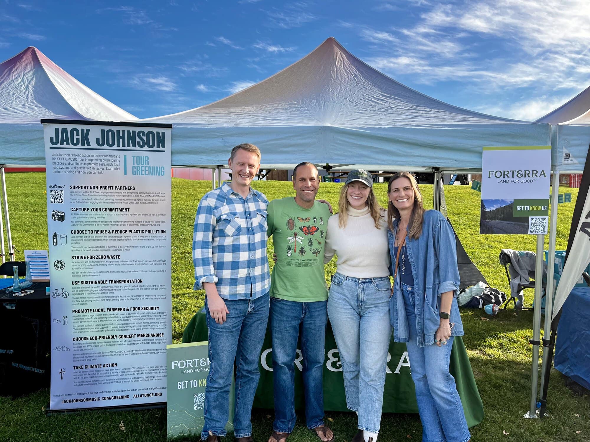 Jack Johnson, Kari, Kim Johnson, and another attendee stand in front of the FTR booth at the All At Once Village Green at The Gorge Amphitheatre.